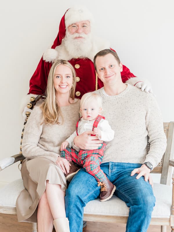 Brian with his wife and their son as a toddler with Santa