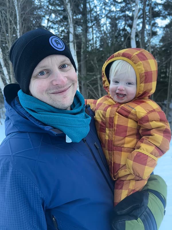 Brian holding his son in the snow